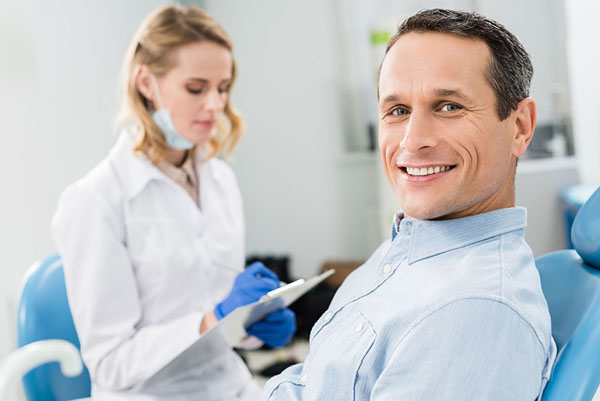 middle-aged man smiling at his dental visit